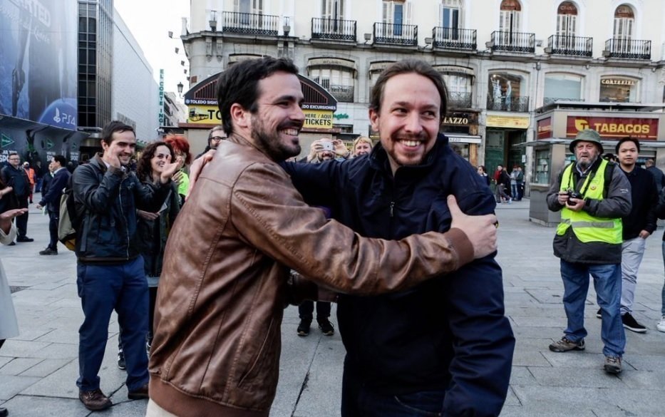 Alberto Garzón y Pablo Iglesias se abrazan en la Puerta del Sol.
