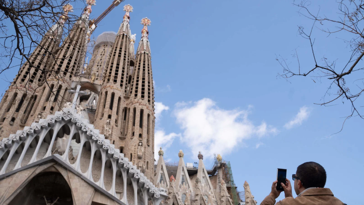 Un turista saca una foto junto a la Sagrada Familia, en Barcelona. Foto: David Zorrakino / Europa Press
