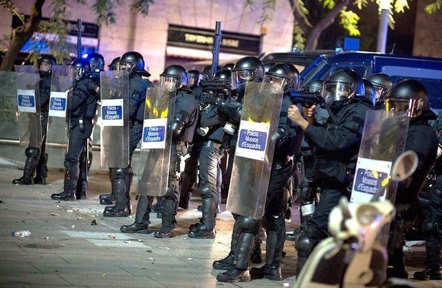 Antidisturbios de los Mossos apuntan con las lanzaderas de precisión en una manifestación.