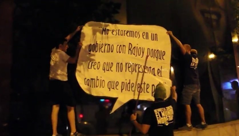 Militantes del Hogar Social Madrid pegan carteles en la sede de Ciudadanos.